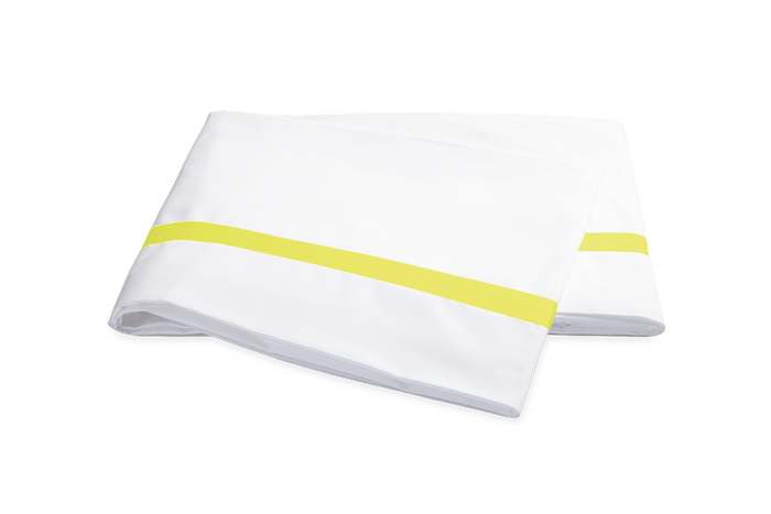 Matouk Lowell percale sheet set styled on a bed — Rafael Interiors, NYC showroom.